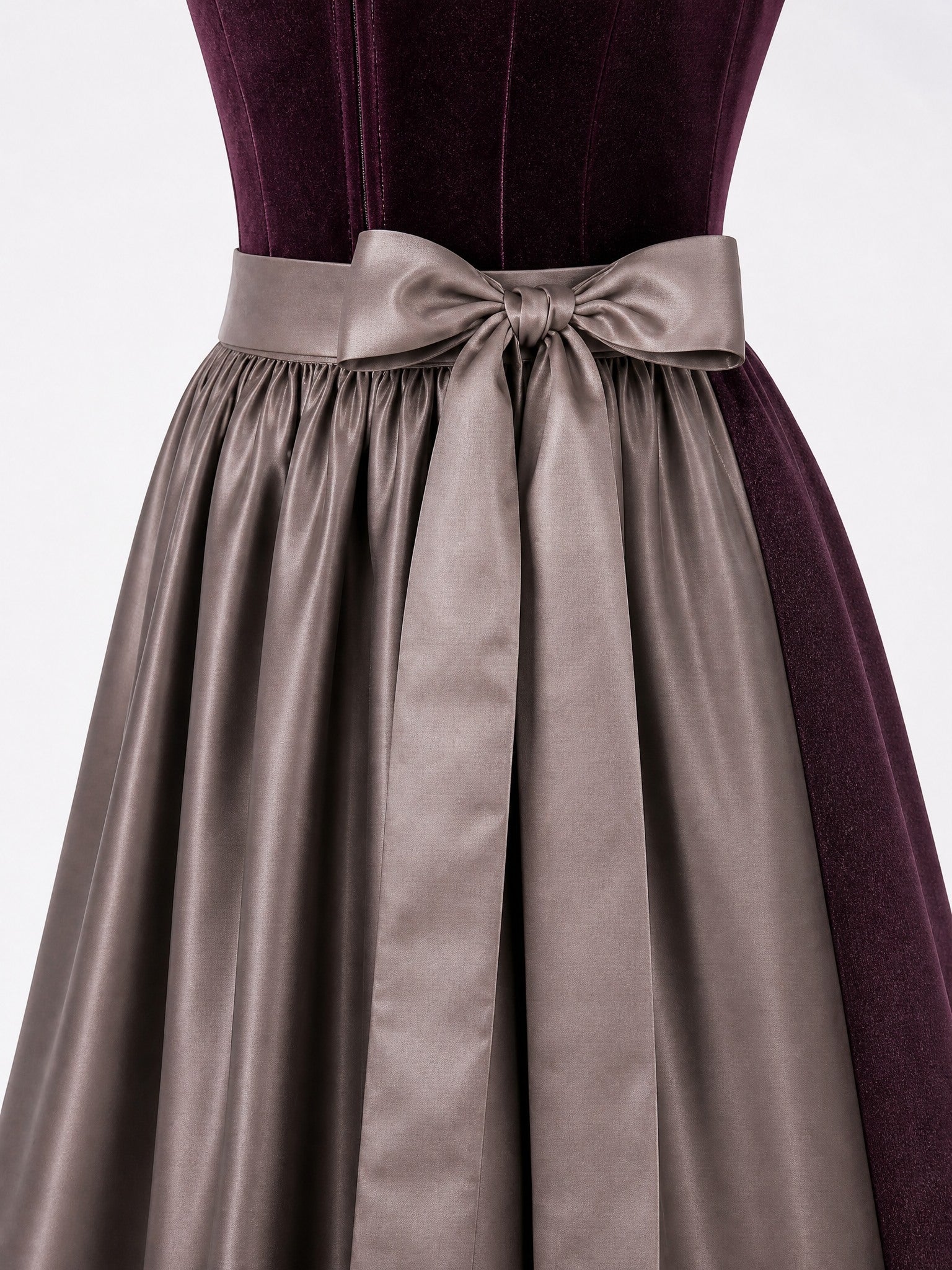 Dirndl Amelia in Brombeere mit Taupe Schürze - Detailansicht Taille und Schleife