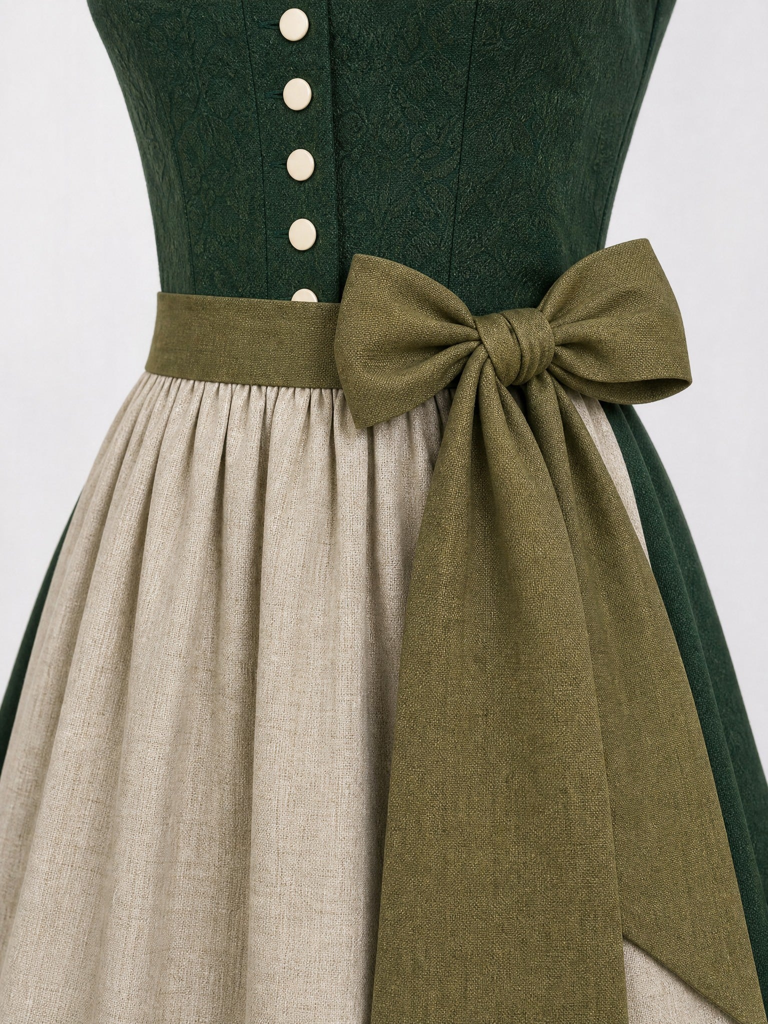Dirndl Freya in Waldgrün mit Haferbeige Schürze - Detailansicht Taille und Schleife