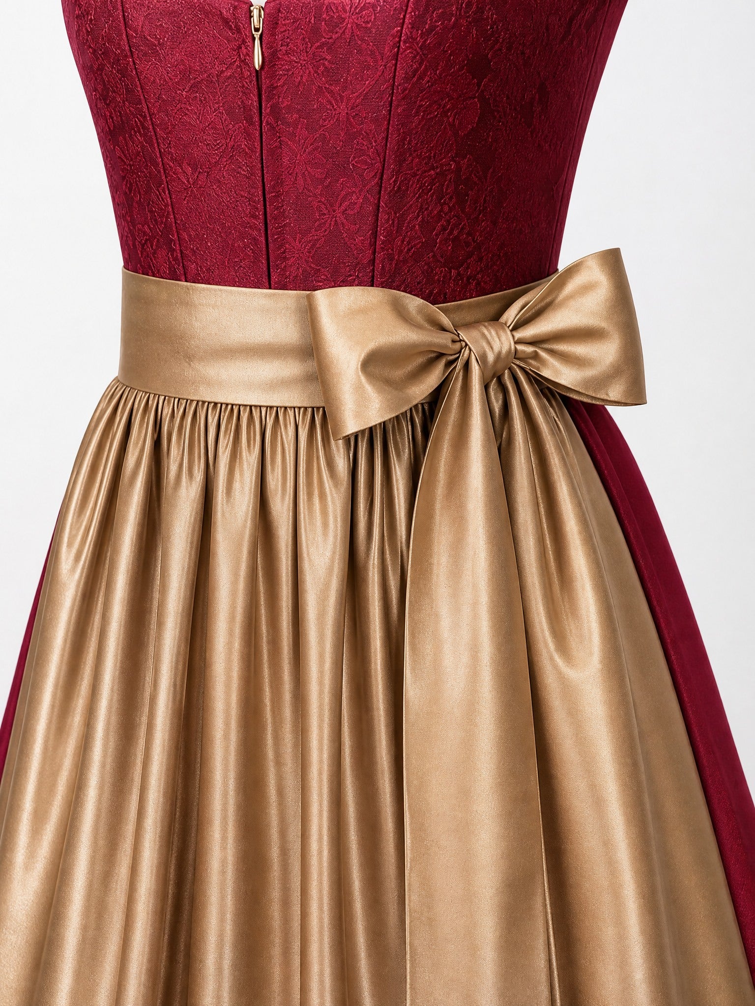 Dirndl Thea in Cranberryrot mit Antikgold Schürze - Detailansicht Taille und Schleife